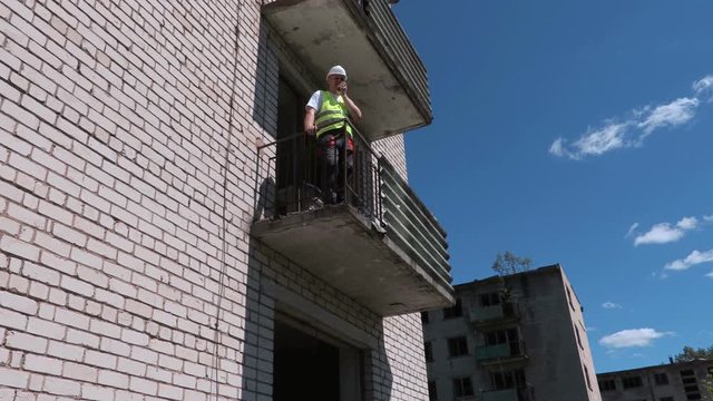 Builder on walkie talkie shows thumb down