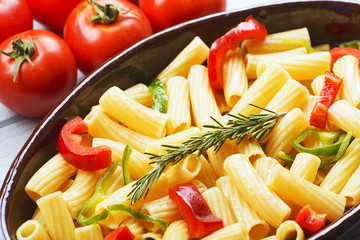 Close-up view of bowl with vegetable served on table with fresh tomatoes.