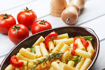 Close-up view of bowl with vegetable served on table with fresh tomatoes. Horizontal studio shot.