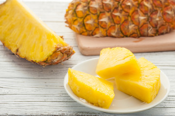 slice of pineapple in white plate on wooden table