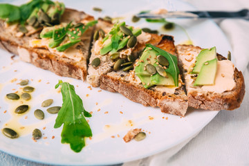 toasted rye bread with sliced avocado and herbs, simple rustic sandwich