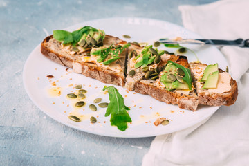 toasted rye bread with sliced avocado and herbs, simple rustic sandwich