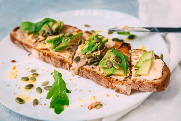 toasted rye bread with sliced avocado and herbs, simple rustic sandwich