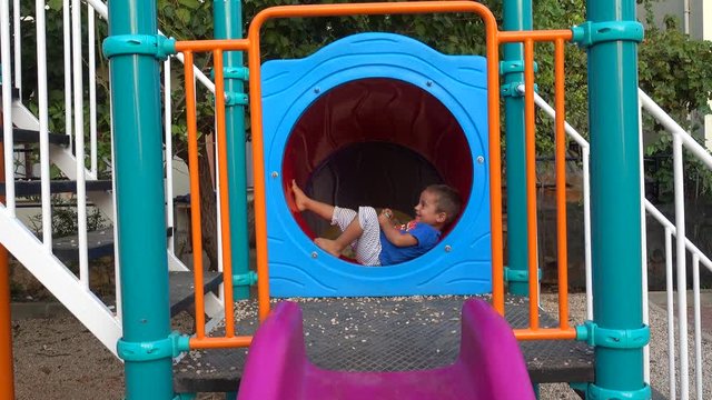 4K Cute child found a cozy place to rest at the children plaground