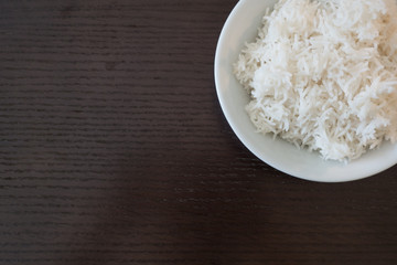 rice in white bowl on wood table with space
