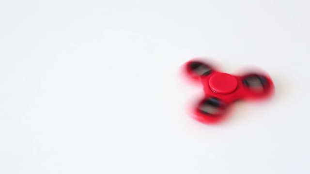 close up of popular toy fidget spinner rotating over white background