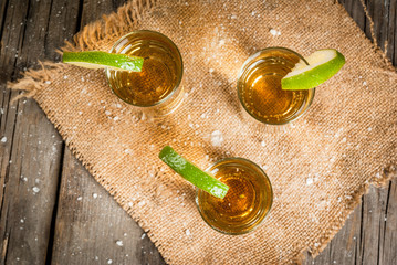 Traditional Mexican alcoholic beverage is a golden tequila. In tall glasses, with a slice of lime...