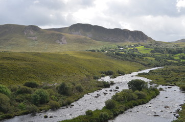 Small River Flow in Green Vegetation and Mountain Landscape in a National Road in Ireland