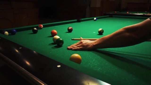 Playing billiards, blowing a cue on the ball, the ball hit the pocket, the ball did not hit the pocket, misfire, hit, American billard, pool, green billiard table, the man plays billiards, breaking