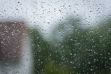 Am Fenster sammeln sich Regentropfen auf der Scheibe
