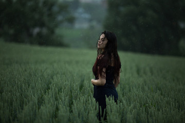 Natural female beauty in summer rain. Beautiful woman walking in the summer rural meadow in the rain. Dramatic photo. Freedom concept background. Beautiful carefree woman in rainy weather. - 162669406