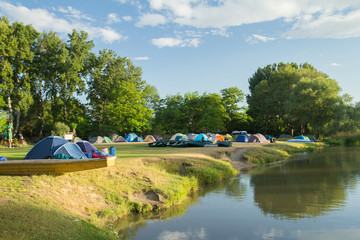 camping area with tents near river