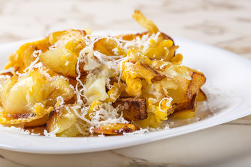 Fried potatoes with scrambled eggs and parmesan cheese