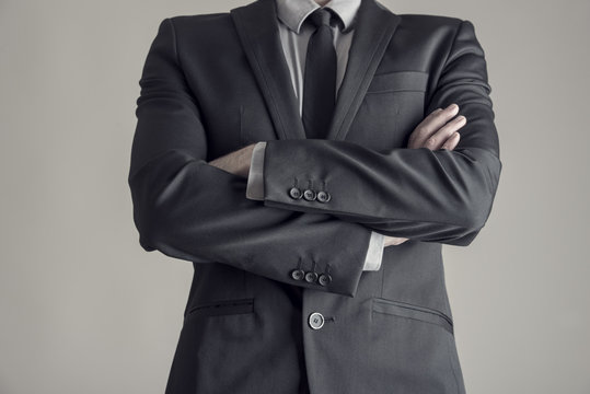 Torso of a businessman standing with folded arms