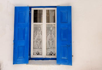Blue and white vintage window with lace curtain