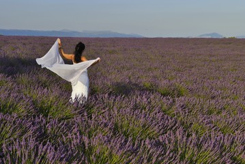 white dressed woman dancing in lavender field, Valensole, Provence, France