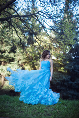 Young beautiful girl in a lush blue dress