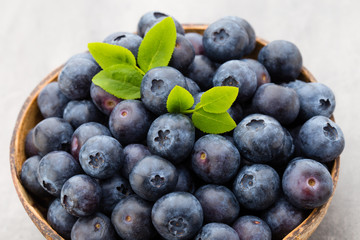 Fresh blueberries natural coconut in a bowl on a gray background.