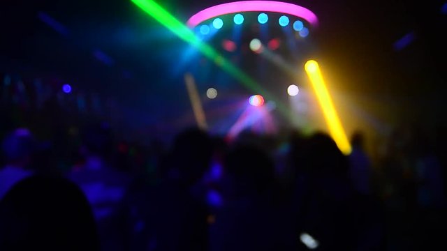   blurLight in club party Show And Silhouette hands of audience crowd people use smart phones enjoying the club party with concert. Blurry night club DJ party people enjoy of music dancing sound.