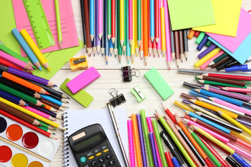 school and office supplies. school background. colored pencils, pen, pains, paper for  school and student education on blue wood background. top view with copy space