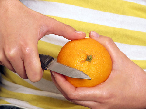 Pelando una mandarina, quitando concha a una mandarina. Stock
