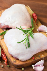 Raw chicken thighs on cutting board.