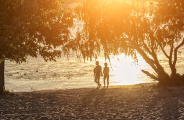 Two young lovers are walking on the beach