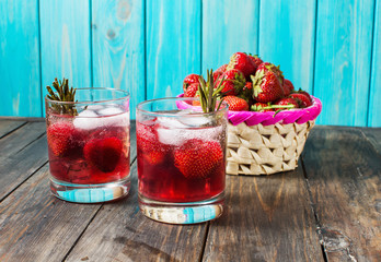 Cocktail-mocktail. Fruity cocktail drink decorated with frozen or fresh raspberry, strawberry, rosemary, ice and soda. Domestic cocktail with ice and rosemary