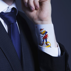 A partial view of a businessman with a Joker card in a sleeve as symbol of cheating and dishonest games (Business, fraud, profit, crime, money laundering concept) - obrazy, fototapety, plakaty