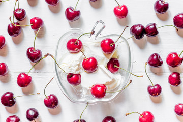 Naklejka na ściany i meble Ice cream decorated with fresh cherry on white table background top view