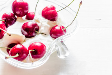 Ice cream decorated with fresh cherry on white table background copyspace close up
