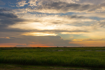 Sunset over the Ocean with puffy Clouds