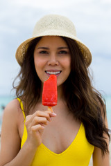 young woman tasting ice cream on the beach
