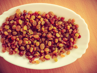 Plate bowl full of yellow dried raisins