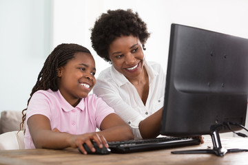 Mother And Daughter Using Computer