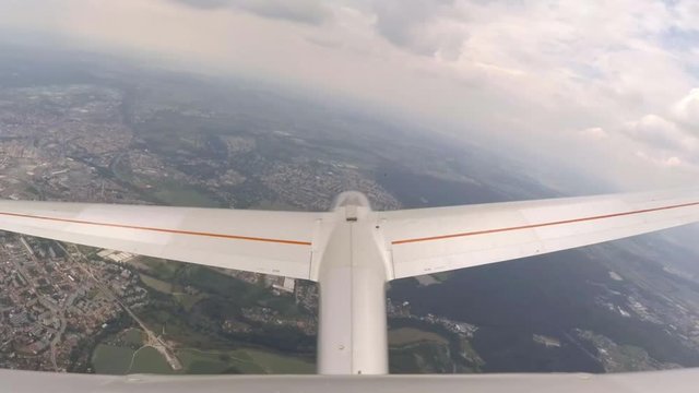 Glider flight over urban landscape around Pilsen in Czech Republic, Central Europe. Footage from action camera placed on aircraft elevator. Soaring under clouds. 