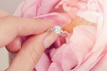 Engagement ring in bride hands. Woman holding jewellery close up. Love, Wedding, Proposing, Marriage concept.