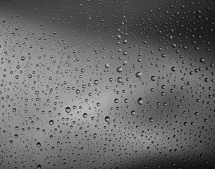 water drops macro on clear surface with vibrant colours in background