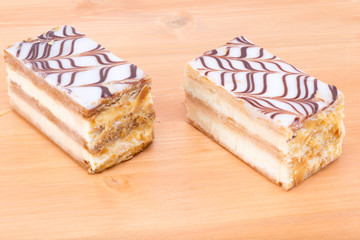 Two delicious Mille feuille Napoleon french custard pastry on a oak wood table