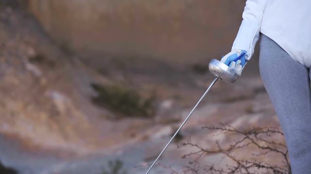 Person hold rapid style sword in hand close up