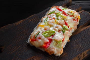Delicious japanese rice pizza with shrimps served on rustic wooden table.Tasty appetizing seafood
