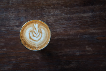 cup of coffee on old wooden desk. Simple workspace or coffee break in morning/ selective focus