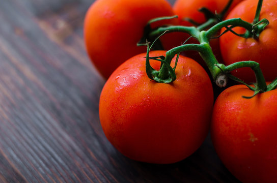 Ripe red tomatoes on a wooden background