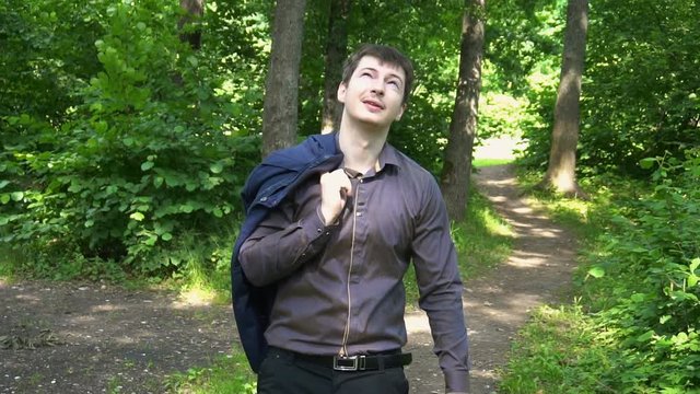 a young businessman goes through the woods on a Sunny day.slow motion