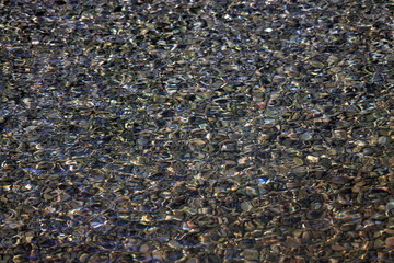 Riverstones through rippling water