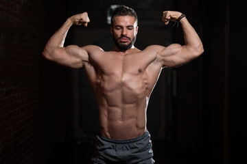 Obraz na płótnie Canvas Fitness Model Posing Double Biceps After Exercises