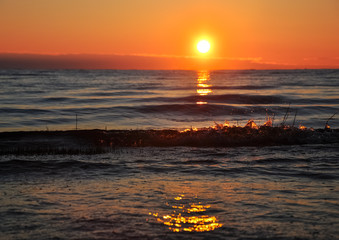 Dawn at the Ladoga. The sun rising above the lake reflecting in the waves