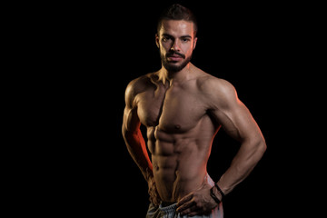 Muscular Model Flexing Muscles On Black Background