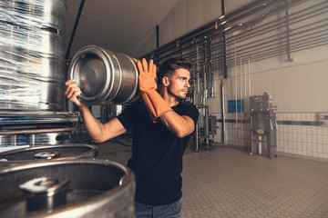 Brewer with large metal container at brewery
