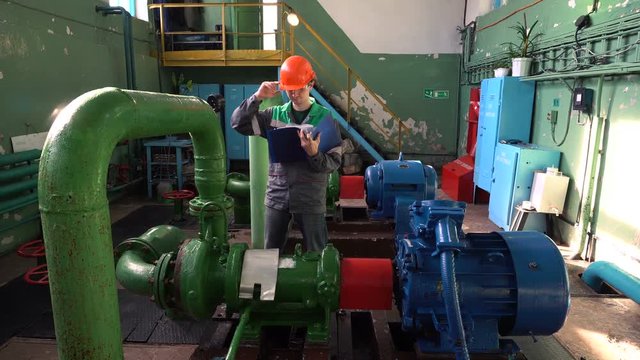 Engineer inspecting machinery water pump in factory